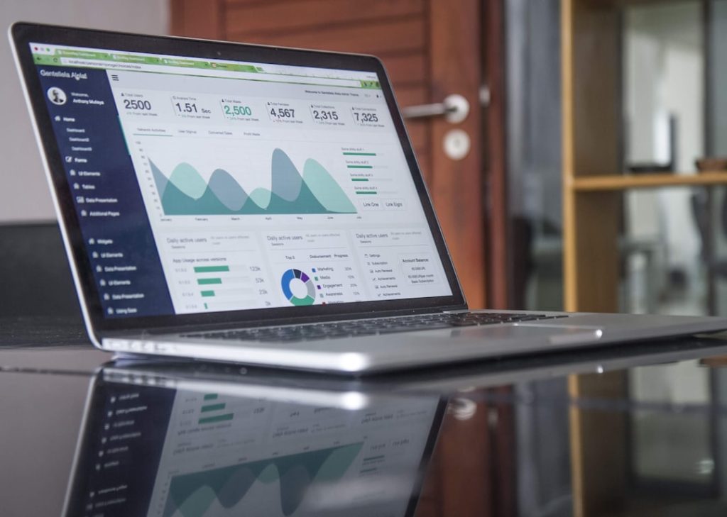 Financial analysis dashboard showing investment statistics and data charts on laptop