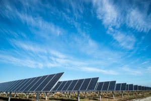 Large-scale utility solar farm with rows of solar panels under dramatic sky, representing Australia's solar energy investment infrastructure. Photo by Lincoln Electric Systems, Lincoln Nebraska