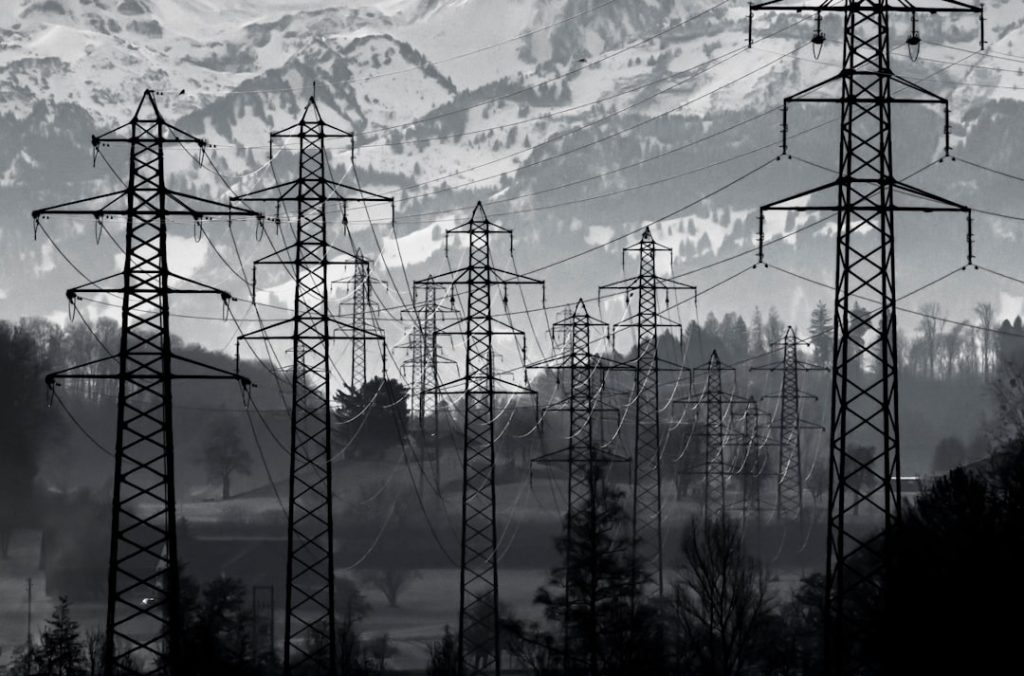 Electricity transmission lines through mountainous terrain representing cross-border power infrastructure