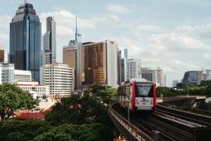 Modern MRT train traveling through Kuala Lumpur with city skyline showing Malaysia's infrastructure development. Photo by Unsplash