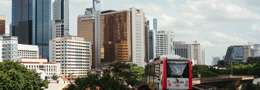 Modern MRT train traveling through Kuala Lumpur with city skyline showing Malaysia's infrastructure development. Photo by Unsplash